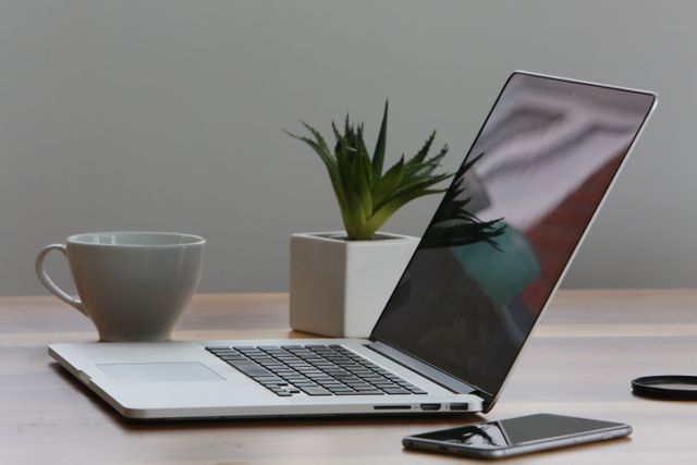 new or refurbished laptop placed on desk next to a mug and planter