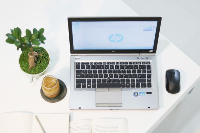 budget laptop placed on desk with a mouse beside it
