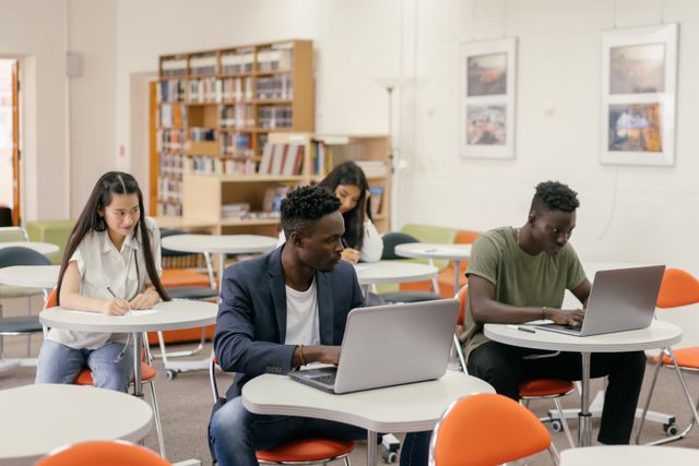 college students in library using laptops